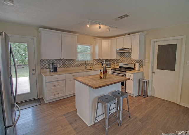 522 Rector, San Antonio, TX 78216 - kitchen featuring stainless steel appliances, a sink, butcher block counters, under cabinet range hood, and wood finished floors