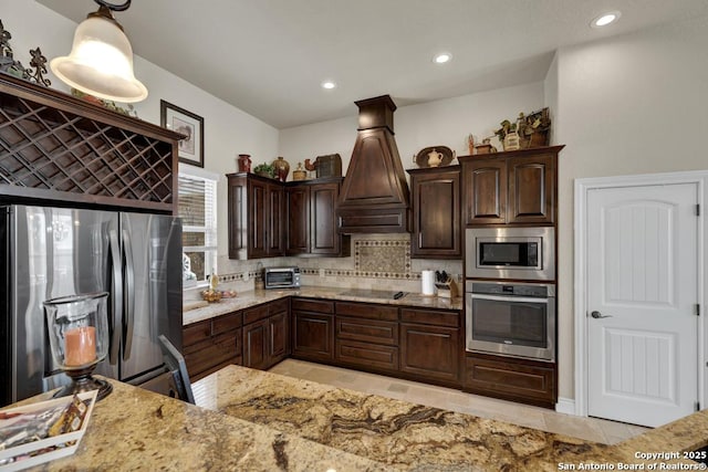 108 Westfield Ln, Vernia, TX 78121 - kitchen with appliances with stainless steel finishes, tasteful backsplash, dark brown cabinets, custom range hood, and light stone counters