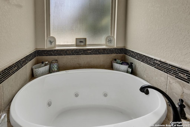 108 Westfield Ln, Vernia, TX 78121 - bathroom with a tub with jets, a textured wall, a wainscoted wall, and tile walls