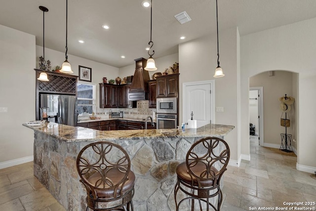 108 Westfield Ln, Vernia, TX 78121 - kitchen featuring stainless steel appliances, stone tile floors, custom range hood, arched walkways, and recessed lighting
