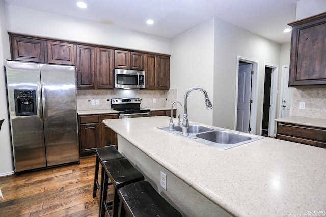 7239 Summer Way, San Antonio, TX 78240 - kitchen with appliances with stainless steel finishes, a sink, dark brown cabinets, dark wood-type flooring, and tasteful backsplash