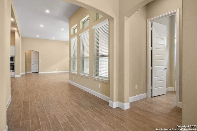 147 Bedingfeld, Shavano Park, TX 78231 - spare room featuring wood finished floors, baseboards, recessed lighting, and arched walkways