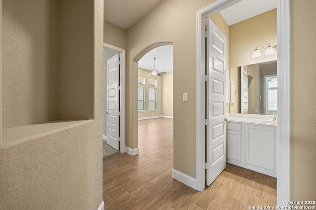 147 Bedingfeld, Shavano Park, TX 78231 - hall with wood finished floors, arched walkways, baseboards, and a sink