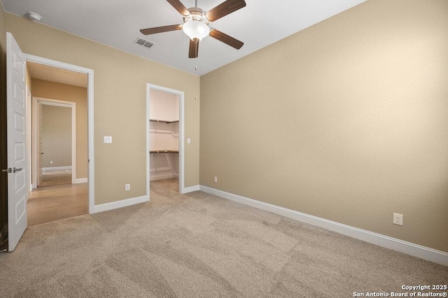 147 Bedingfeld, Shavano Park, TX 78231 - unfurnished bedroom with light colored carpet, a spacious closet, baseboards, ceiling fan, and a closet