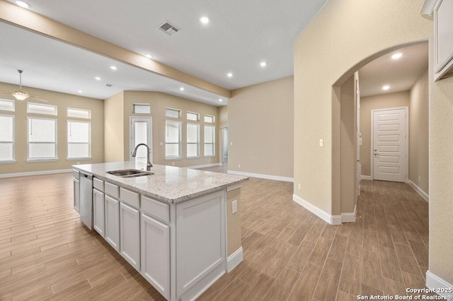 147 Bedingfeld, Shavano Park, TX 78231 - kitchen with a sink, open floor plan, arched walkways, light wood-style flooring, and recessed lighting