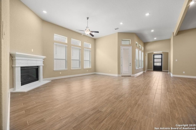 147 Bedingfeld, Shavano Park, TX 78231 - unfurnished living room featuring a ceiling fan, wood finished floors, a glass covered fireplace, baseboards, and recessed lighting