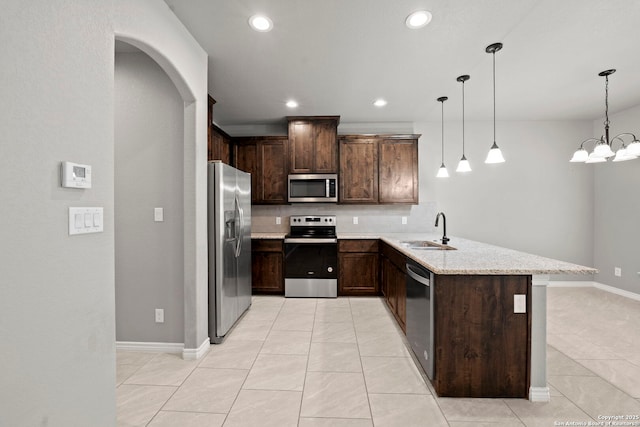 546 Indian Scout, Spring Branch, TX 78070 - kitchen with stainless steel appliances, a sink, a peninsula, dark brown cabinets, and recessed lighting