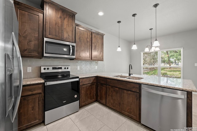 546 Indian Scout, Spring Branch, TX 78070 - kitchen with appliances with stainless steel finishes, a sink, a peninsula, tasteful backsplash, and dark brown cabinets