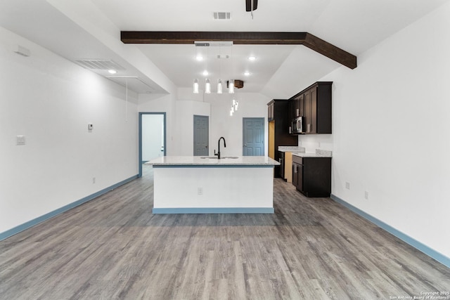 241 Hawthorne, San Antonio, TX 78214 - kitchen with a sink, light wood finished floors, light countertops, stainless steel microwave, and an island with sink