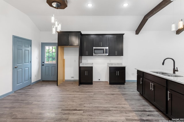 241 Hawthorne, San Antonio, TX 78214 - kitchen with stainless steel microwave, a sink, light wood-type flooring, pendant lighting, and light stone counters