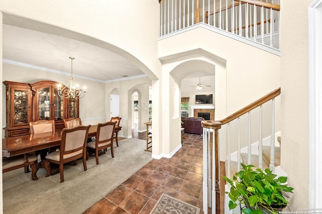 3353 Joshs Way, Marion, TX 78124 - dining space featuring stairs, dark tile patterned flooring, a tiled fireplace, crown molding, and arched walkways