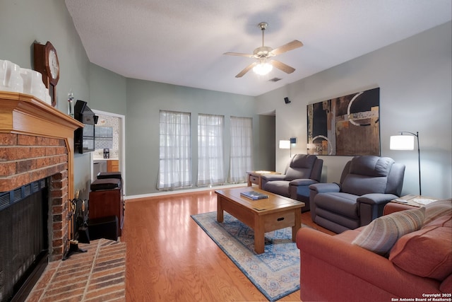 5626 Timber Strm, San Antonio, TX 78250 - living room with ceiling fan, wood finished floors, a brick fireplace, and baseboards