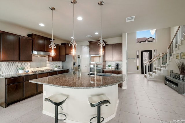 23414 Seven Winds, San Antonio, TX 78258 - kitchen with stainless steel appliances, range hood, an island with sink, decorative backsplash, and dark stone countertops