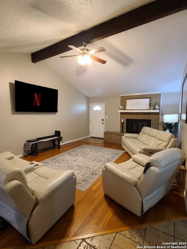 117 Larkspur, Uvalde, TX 78801 - living area featuring a ceiling fan, a textured ceiling, a fireplace, wood finished floors, and baseboards