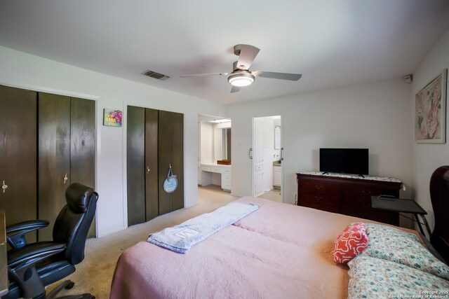 713 Fawndale, Windcrest, TX 78239 - bedroom with light colored carpet, two closets, a desk, connected bathroom, and ceiling fan