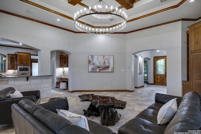 112 Legend Holw, Boerne, TX 78006 - living room with arched walkways, ornamental molding, a towering ceiling, a chandelier, and baseboards