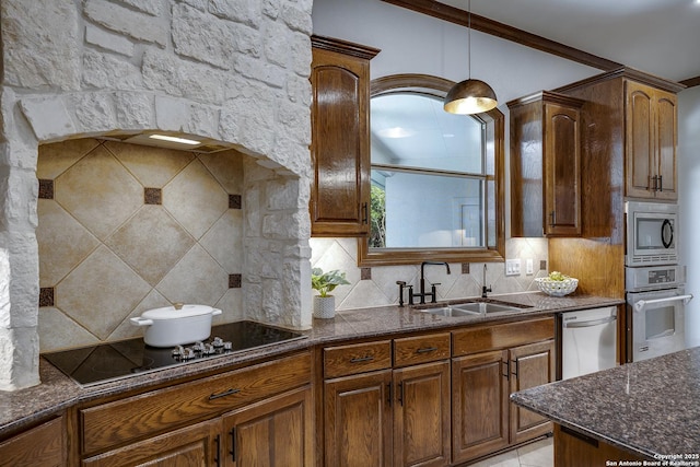 112 Legend Holw, Boerne, TX 78006 - kitchen featuring appliances with stainless steel finishes, a sink, backsplash, dark stone countertops, and decorative light fixtures