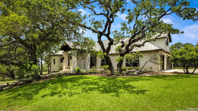112 Legend Holw, Boerne, TX 78006 - mid-century modern home with a standing seam roof, a front lawn, stone siding, metal roof, and an attached garage