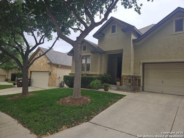 3607 Tea Rose Gln, San Antonio, TX 78259 - view of front of house with stone siding, driveway, stucco siding, and a front yard