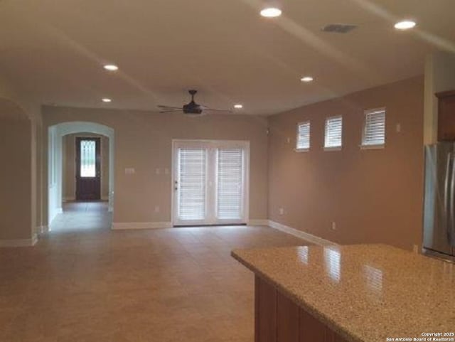 3607 Tea Rose Gln, San Antonio, TX 78259 - unfurnished living room featuring arched walkways, a ceiling fan, recessed lighting, baseboards, and light flooring