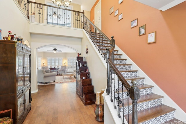 2929 Mccaskey Rdg, San Antonio, TX 78258 - stairway with wood finished floors, ceiling fan, arched walkways, a towering ceiling, and a chandelier