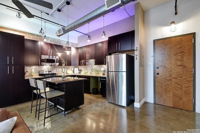 831 S Flores Unit 2212, San Antonio, TX 78204 - kitchen with stainless steel appliances, concrete floors, decorative backsplash, a kitchen breakfast bar, and a high ceiling