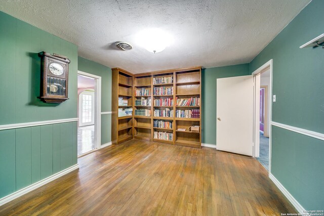 6514 W Ave, Castle Hills, TX 78213 - unfurnished room featuring hardwood / wood-style floors, a textured ceiling, and baseboards