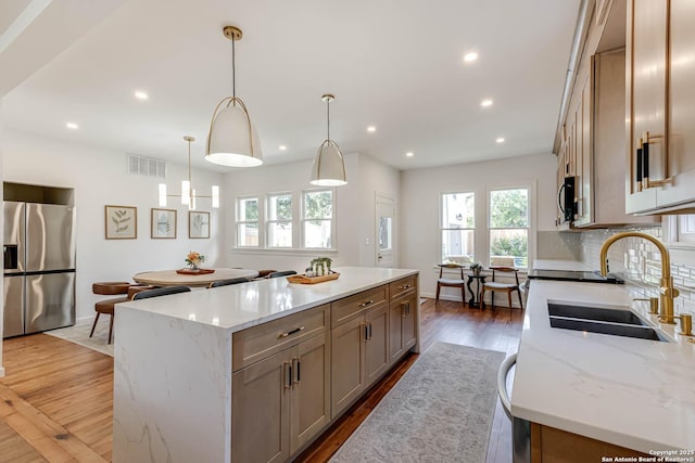 264 E Lullwood, San Antonio, TX 78212 - kitchen with stainless steel fridge with ice dispenser, a sink, a center island, wood finished floors, and recessed lighting