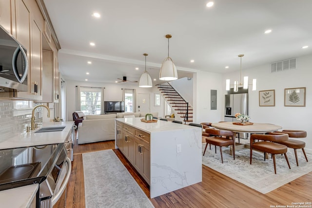 264 E Lullwood, San Antonio, TX 78212 - kitchen with stainless steel appliances, a sink, open floor plan, wood finished floors, and recessed lighting
