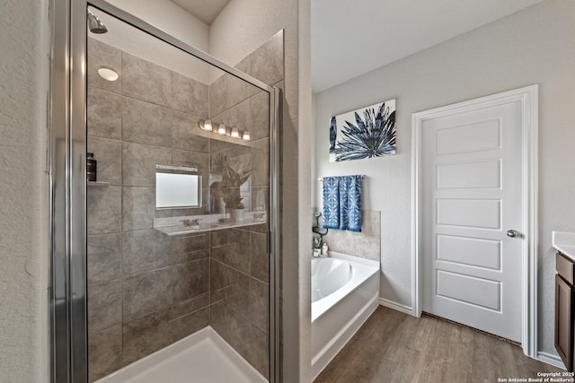 9302 Graze Land Dr, San Antonio, TX 78211 - full bath with a garden tub, wood finished floors, a shower stall, vanity, and a textured wall