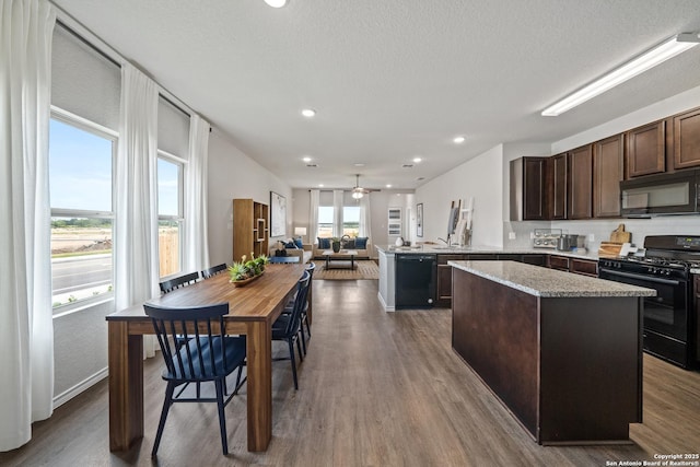 9302 Graze Land Dr, San Antonio, TX 78211 - kitchen with black appliances, dark brown cabinets, a kitchen island, open floor plan, and ceiling fan
