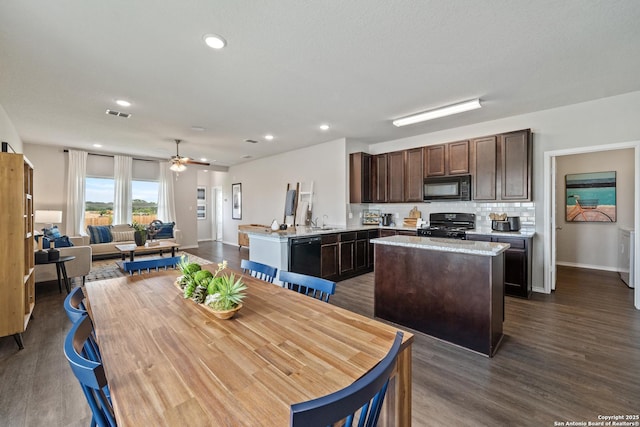 9302 Graze Land Dr, San Antonio, TX 78211 - kitchen with black appliances, dark brown cabinetry, a kitchen island, a sink, and dark wood-style flooring