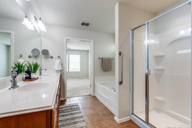 10907 Shoo Fly, San Antonio, TX 78245 - full bath featuring double vanity, a shower stall, a bath, tile patterned flooring, and a textured ceiling
