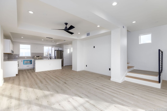 310 S Mesquite St Unit 102, San Antonio, TX 78203 - unfurnished living room with a sink, recessed lighting, baseboards, stairway, and light wood-style floors