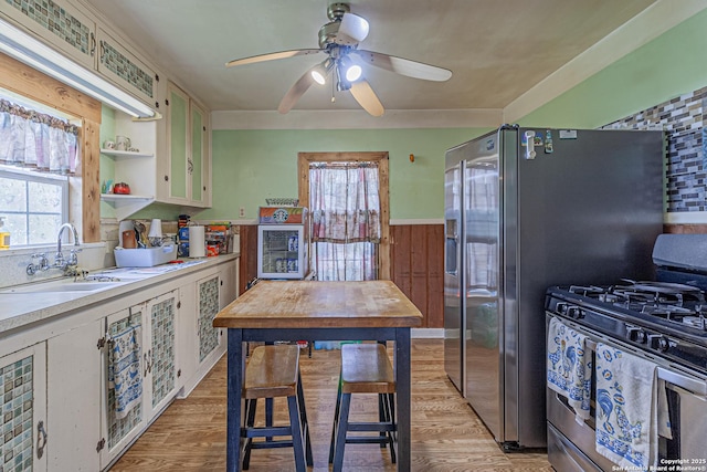 935 Gembler, San Antonio, TX 78219 - kitchen with gas stove, a sink, light countertops, ceiling fan, and light wood-style flooring