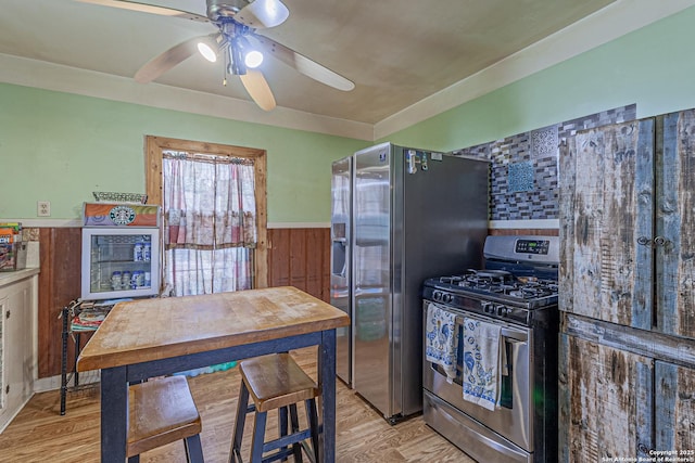 935 Gembler, San Antonio, TX 78219 - kitchen with stainless steel appliances, ceiling fan, a wainscoted wall, and light wood finished floors