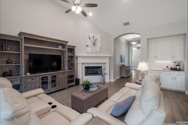28515 Vogelsdorf, Boerne, TX 78006 - living room with arched walkways, a ceiling fan, light wood-style flooring, high vaulted ceiling, and a fireplace