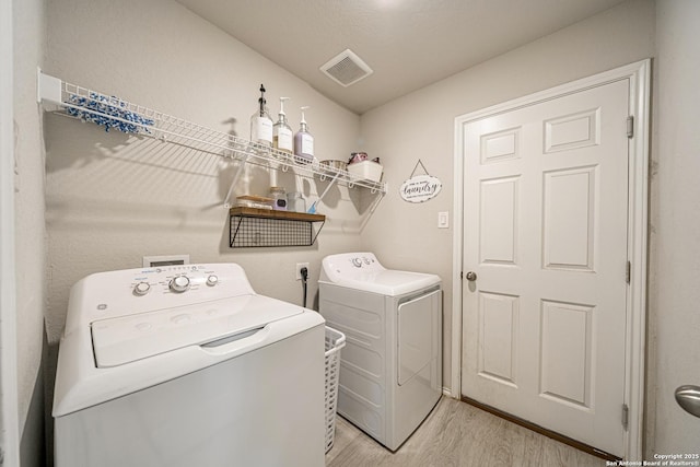 14616 Stable Spgs, Elmendorf, TX 78112 - laundry area with light wood-type flooring and washer and clothes dryer
