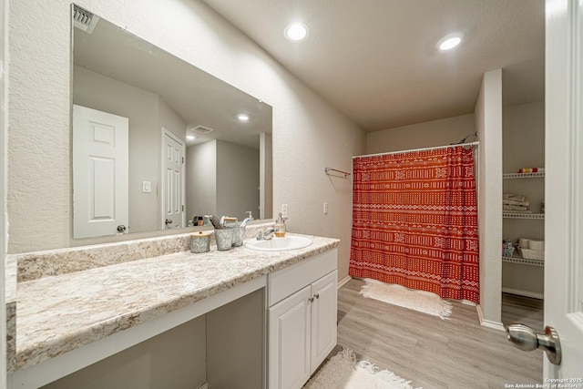 14616 Stable Spgs, Elmendorf, TX 78112 - bathroom featuring vanity, wood finished floors, recessed lighting, baseboards, and a textured wall
