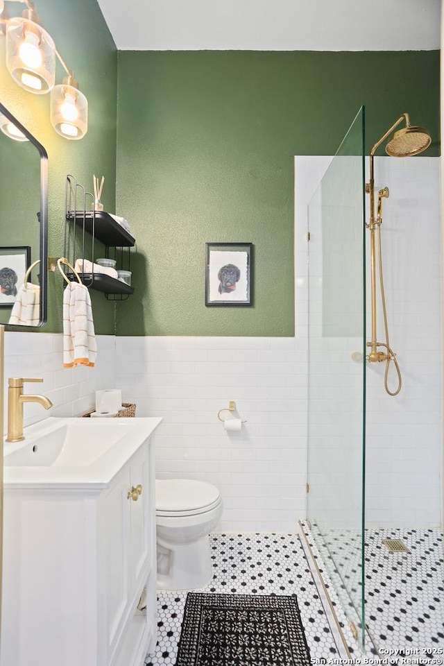 1106 W Summit Ave, San Antonio, TX 78201 - bathroom featuring vanity, tile walls, a tile shower, toilet, and a wainscoted wall