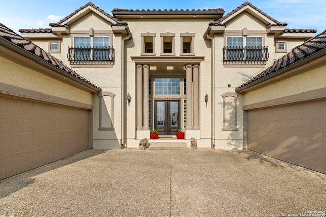 21302 Ronda De Cadiz, San Antonio, TX 78257 - entrance to property featuring driveway, french doors, stucco siding, and a garage