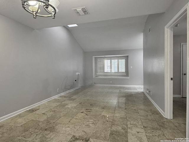 201 Craig Pl Apt B, San Antonio, TX 78212 - empty room with a chandelier, vaulted ceiling, stone finish floors, and baseboards