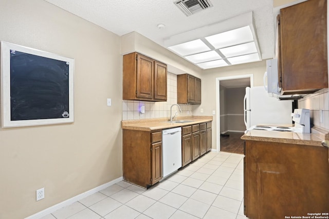 7738 Chambers Rd Unit 1203, San Antonio, TX 78229 - kitchen with white appliances, a sink, backsplash, baseboards, and light tile patterned floors