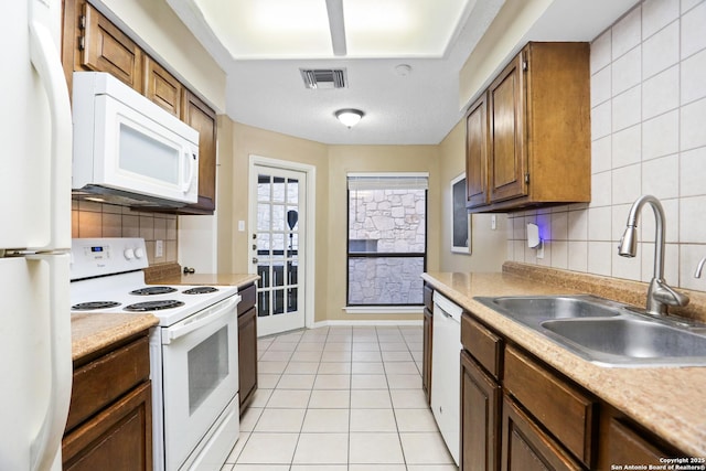 7738 Chambers Rd Unit 1203, San Antonio, TX 78229 - kitchen with white appliances, a sink, tasteful backsplash, and light countertops