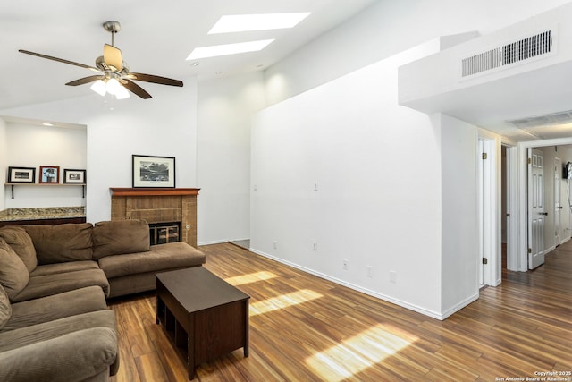 8633 Datapoint Unit 236, San Antonio, TX 78229 - living room with a skylight, high vaulted ceiling, wood finished floors, a brick fireplace, and baseboards