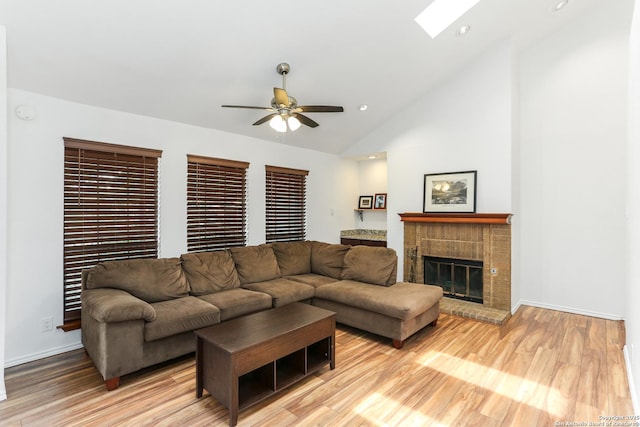 8633 Datapoint Unit 236, San Antonio, TX 78229 - living area with a ceiling fan, light wood finished floors, a fireplace, a skylight, and baseboards