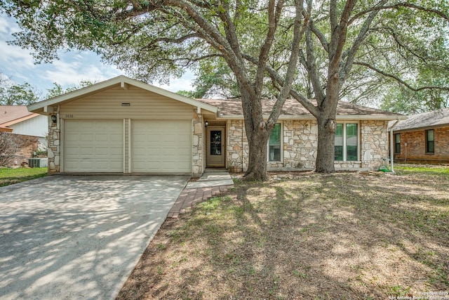3030 Heidi St, San Antonio, TX 78247 - view of front of property featuring stone siding, an attached garage, driveway, and central air condition unit