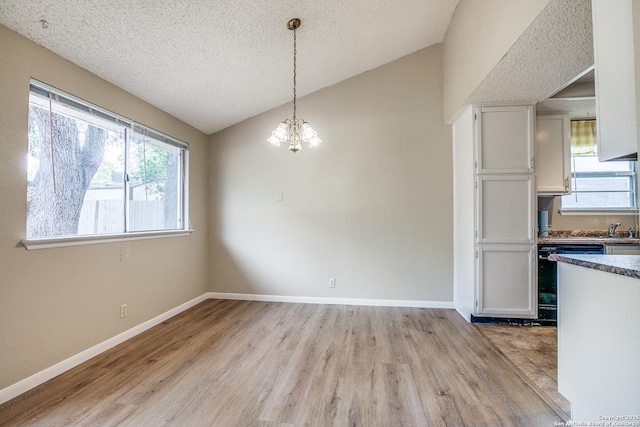 3030 Heidi St, San Antonio, TX 78247 - unfurnished dining area featuring light wood-style flooring, vaulted ceiling, a chandelier, a textured ceiling, and baseboards