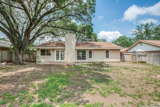 3030 Heidi St, San Antonio, TX 78247 - back of property with a chimney, a fenced backyard, a wooden deck, and french doors
