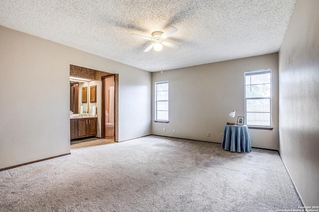 3030 Heidi St, San Antonio, TX 78247 - unfurnished bedroom featuring carpet floors, a textured ceiling, ensuite bathroom, ceiling fan, and baseboards